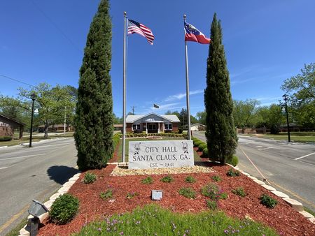 Santa Claus City Hall sign with flags and flower beds